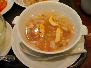スープのアップ写真。白いカップに、玉子やひき肉、茸がちらほら覗いているとろみのあるスープです
