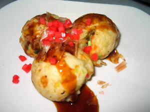 白いお皿に、丸まるのたこ焼きが3つ。ソースがかかって、紅しょうがもちらほらかかっています。削り節も見えてます