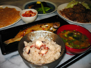 ちょっと斜めから撮った写真。ご飯、味噌汁が手前側、向こうに焼き魚、更にその奥に、玉子焼き、キムチ、ナスの焼き物、一番奥に生姜焼きが見えます。