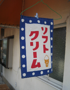 白地に青に白の水玉の縁取り、赤い文字でソフトクリームと書かれた垂れ幕。こちらは小さなソフトクリームの絵も描かれています。