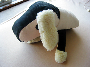 白と黒のツートンカラーのぬいぐるみ。犬の顔になっていて、前足もついています。頭でっかちのこの胴体には、手を入れる事が出きるようになっていて、齧られても痛くないようにたっぷりの綿が入っています。まん丸の目が愛くるしいぬいぐるみです。