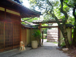 純和風な格子戸の玄関。入り口両脇に狛犬風なシーサーの置物が。