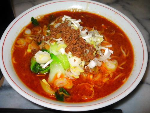 淵に一本赤い線が入ったラーメン丼、真っ赤な汁が辛さを象徴しているようです。青梗菜の緑、ネギの白、ひき肉の茶、それらが真っ赤なスープの上に浮いていて、見てるだけで食欲をそそります。
