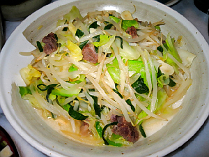 和風の大きめの丸皿、ややグレーがかっています。もやしやキャベツ野菜炒めがたっぷりと盛られています。
