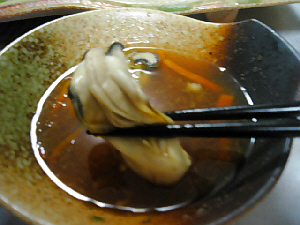 鍋に付き物の小鉢。ポンズに浸けて引き上げたばかりの牡蠣。箸でつまんでパチリです。