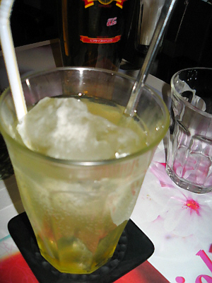 黄色い飲み物はパッションフルーツの炭酸割り。そのグラスの向こう側にノンアルコールの瓶が見えています。