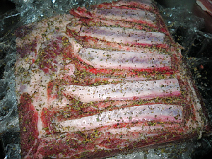 大きな豚バラ肉の塊。ハーブや塩、コショウを擦り込んだところ