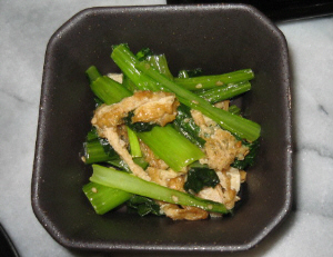 四角い黒っぽい器に盛られた小松菜と油揚げ。小松菜の緑が色鮮やかです。