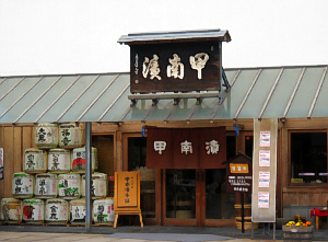 甲南漬と大きく書かれた看板の店構え。ここは高島忠雄の実家です。お店の入り口の脇には酒樽がピラミッド型に積んであります。