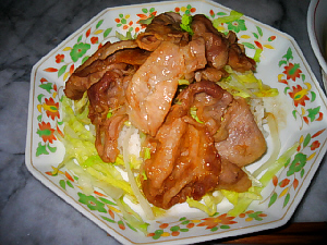 中華皿に少量のご飯、たっぷりのレタスの千切り、その上に薄切り豚肉のしょうが焼きが乗った、サイドディッシュ。