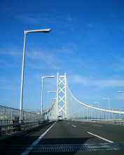 明石海峡大橋を渡っている最中に車の中から撮った一枚。青い空に白いブリッジがそびえ立ち、美しい光景です。