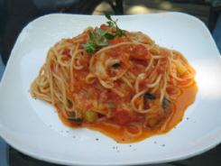 トマトソースのパスタ。白いお皿にトマトの色が映えています。