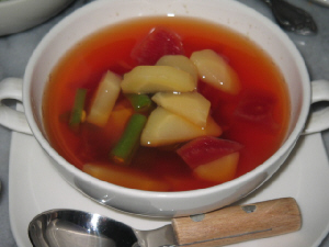 白い両手持ちのスープカップに、野菜がゴロゴロの赤いスープが入っています。