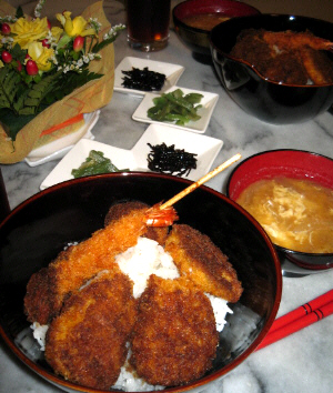 串カツの具を乗っけた串カツ丼、となりに味噌汁椀、その向こう側に漬物と昆布の盛られた白いお皿が見えます。