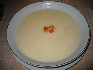 白いお皿の上に、大きな白いスープ皿。コーンポタージュスープがたっぷり。浮き身にクルトンが乗っています。