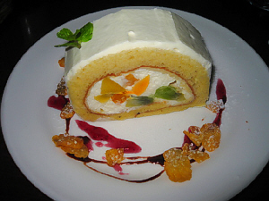 同じく白い丸皿に盛られたロールケーキ。ロールの中には、生クリームとフルーツがたっぷり。