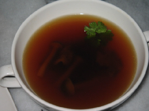 白いスープカップに入った濃い目の茶色のスープ。