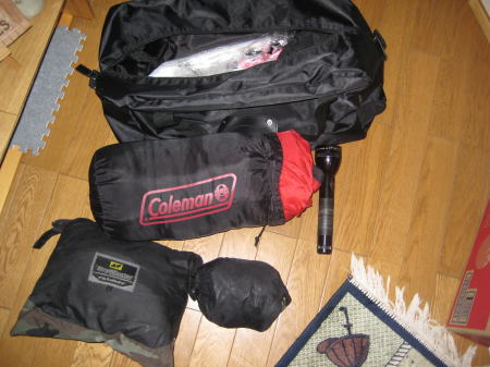 キャンプ用品や雨具が並べられたツーリング荷物一式