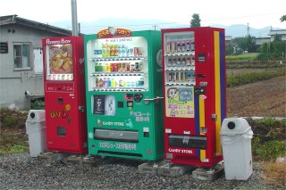 田舎の空き地に3台並んだ自動販売機 自動販売機と地域経済